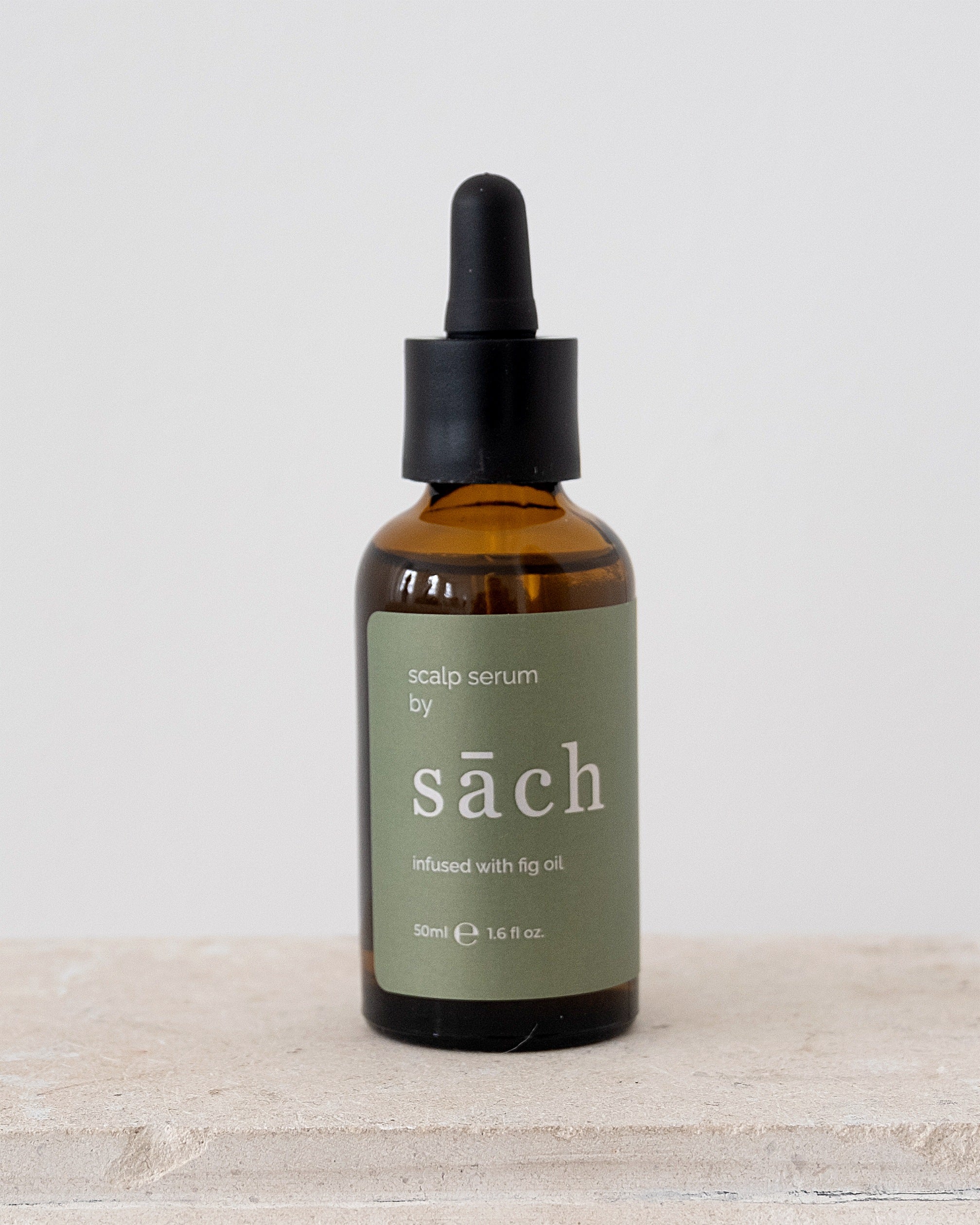 sāch infused with fig oil scalp serum bottle on plain background